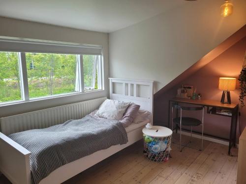 a small bedroom with a bed and a window at Rustic, Scandinavian house close to Reykjavik in Garðabær