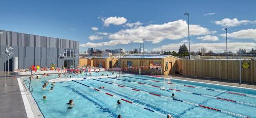 a large swimming pool with many people in it at Rustic, Scandinavian house close to Reykjavik in Garðabær