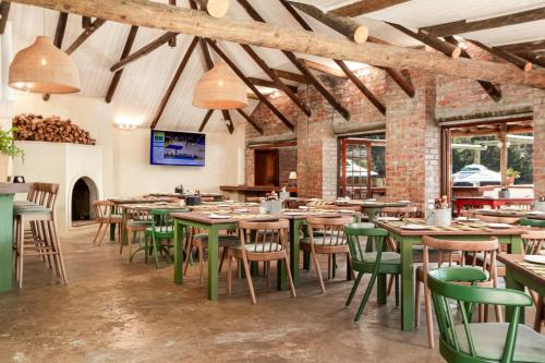 Un comedor con mesas y sillas y ventanas. en Elgin River Lodge, en Elgin