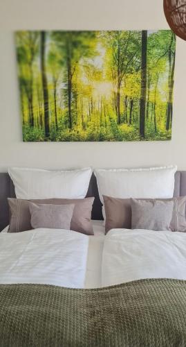 a bedroom with two beds and a painting on the wall at Delikanto Apartments in Unterlüß