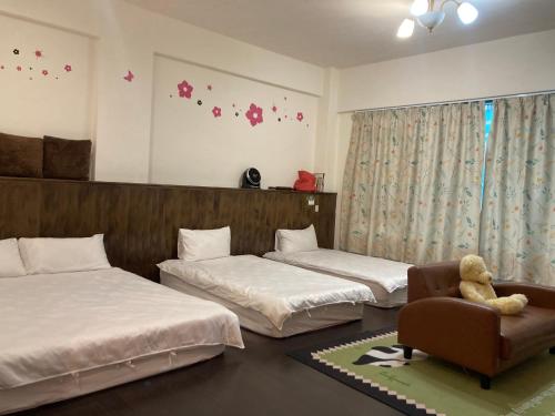 um quarto com duas camas e um ursinho de pelúcia em uma cadeira em 福田民宿 台東民宿476號 em Guanshan