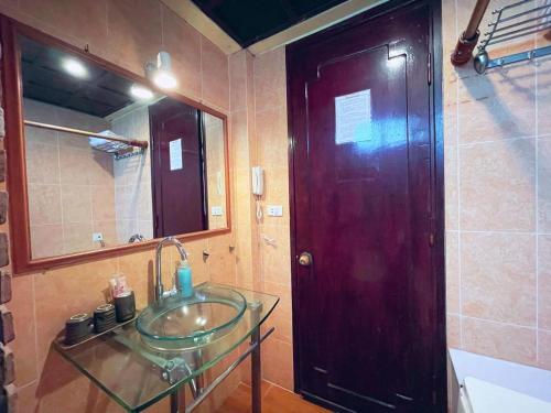 a bathroom with a glass sink and a mirror at Maison De Charme 02 in Hanoi