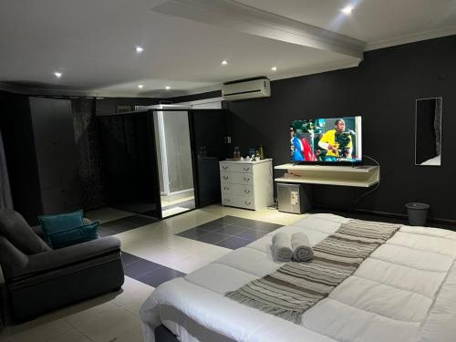 MatolaMATOLa GUEST HOME的一间卧室设有一张大床和一台墙上的电视。