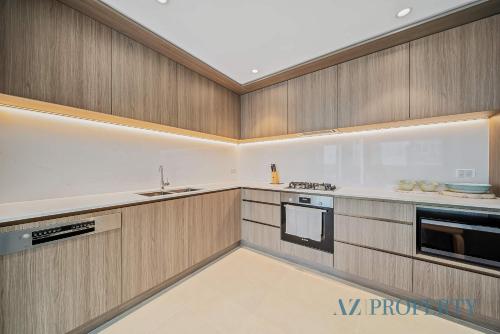 a large kitchen with wooden cabinets and appliances at Brand new Luxurious 2 Bedroom Perth CBD in Perth