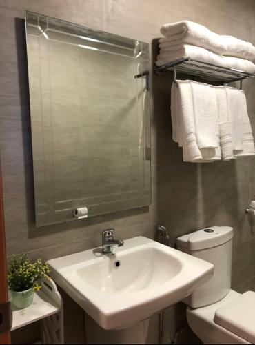a bathroom with a sink and a toilet and a mirror at Antara Residences - 1BR in Talisay