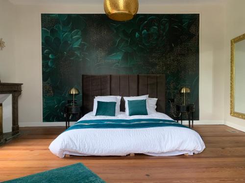 a bedroom with a large bed with two pillows at La Tour du Maine in Marmande