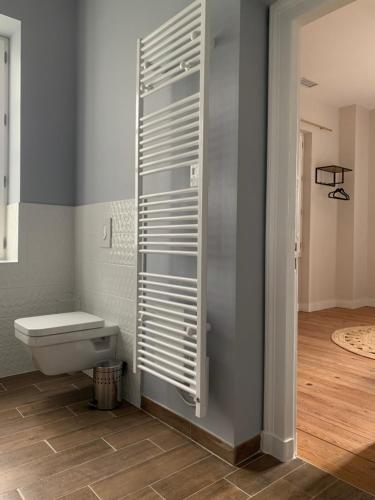 a bathroom with a toilet with a shutter on the wall at La Tour du Maine in Marmande