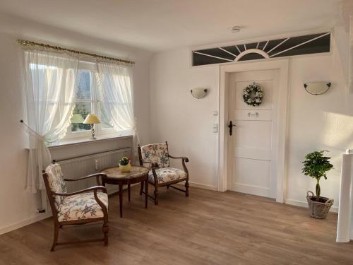 a living room with chairs and a table and a window at Landhaus Saaleck in Naumburg