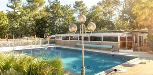 南莱潘Bungalow confortable à Nans-les-Pins de 30 m²的建筑物前有一个带灯杆的游泳池