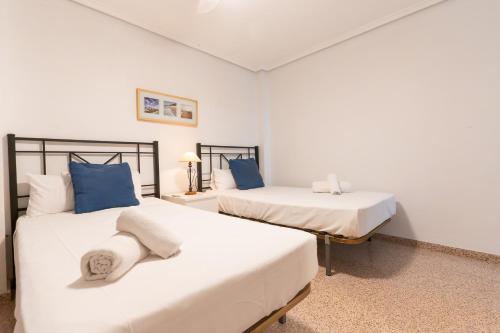 two beds in a room with blue and white at rentafive - Nuevo - Centro - A/C in Santa Pola