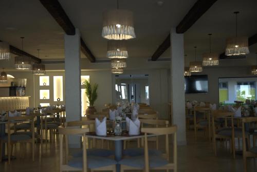 a dining room with tables and chairs and chandeliers at Sunny Days Mirette Family Resort in Hurghada