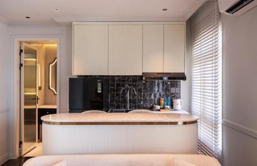eine Küche mit weißen Schränken und einer Arbeitsplatte in der Unterkunft AMANA Boutique Hotel - Thân Văn Nhiếp in Ho-Chi-Minh-Stadt
