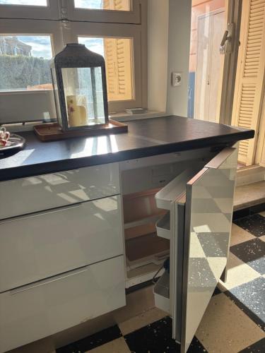 una cucina con piano di lavoro nero e finestra di Appartement Louis a Cap d'Ail