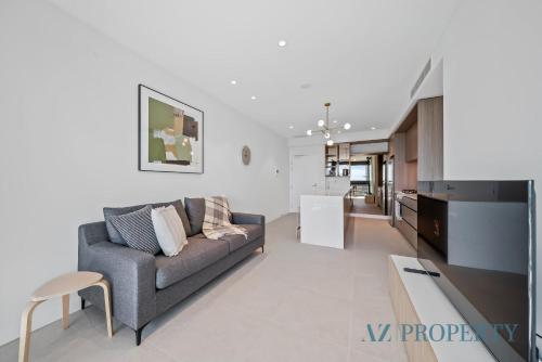 una sala de estar con un sofá y una mesa en Brand new Luxurious 1 Bedroom Perth CBD, en Perth