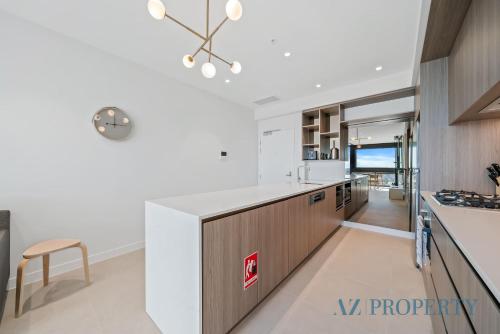 a kitchen with white walls and wooden cabinets and a table at Brand new Luxurious 1 Bedroom Perth CBD in Perth