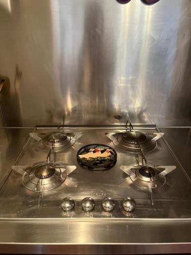a stove top with three burners on top of it at La terrazzina nel borgo apt dimora storica toscana pool&garden in Lano