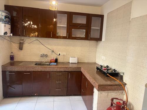 The Green Door في Lāndrān: مطبخ مع دواليب بنية ومغسلة