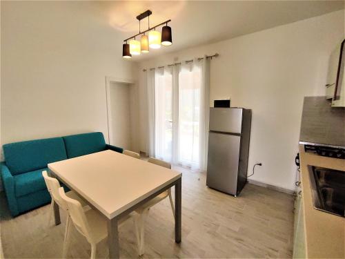 un soggiorno con un tavolo e un frigorifero di Villa Bungalow 2 a Rosolina Mare