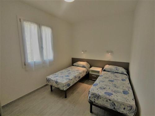 una camera da letto con due letti e una finestra di Villa Bungalow 2 a Rosolina Mare