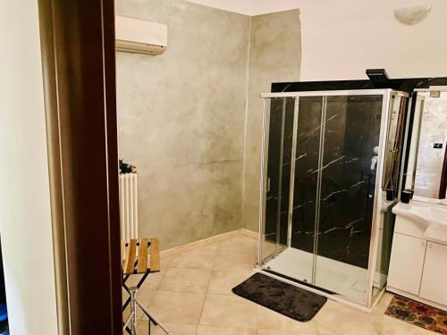 una ducha con puerta de cristal en una habitación en Armony B&B, en Bitritto