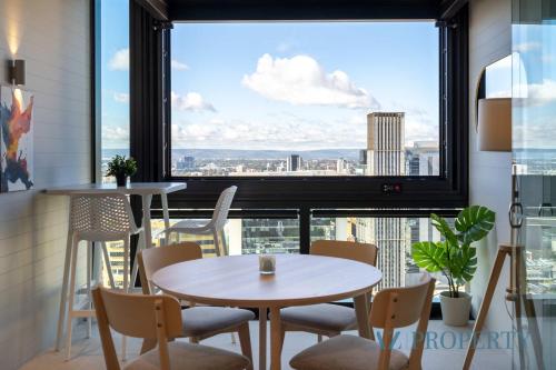 a room with two tables and chairs and a large window at Perth's Modern 1BR Apartment with Pool & Gym - City Living in Perth