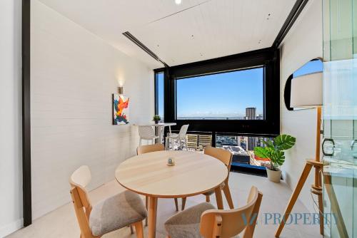 a dining room with a table and chairs and a window at Perth's Modern 1BR Apartment with Pool & Gym - City Living in Perth