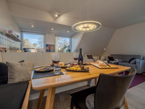 a dining room table with a plate of food and wine glasses at Haus Svenja in Westerland (Sylt)