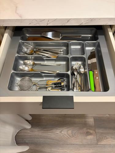 a drawer filled with cooking utensils in a kitchen at Mistera rezidence in Jelgava