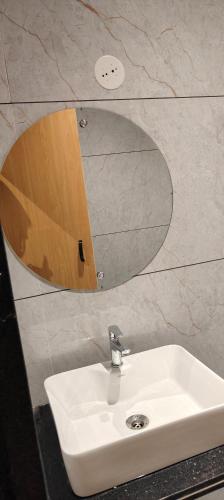 a white sink in a bathroom with a mirror at Hotel Abhishek Pride Shani Shinganapur in Godhegaon