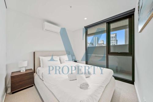 a bedroom with a white bed and a large window at PerthViews Modern with Pool Gym in Perth
