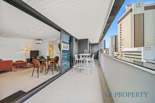 a balcony with a view of a living room and dining room at PerthViews Modern with Pool Gym in Perth