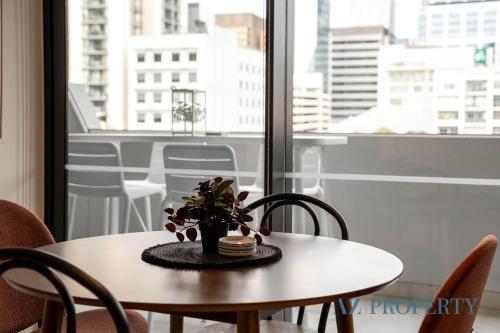 a table with a potted plant on it in front of a window at PerthViews Modern with Pool Gym in Perth