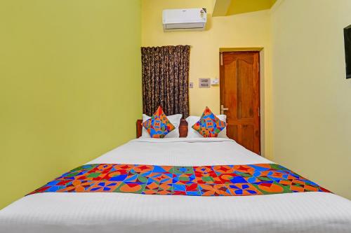 a bedroom with a bed with a colorful comforter at FabHotel Martine's Residency - French Colony, 5 Mins from Rock Beach in Puducherry