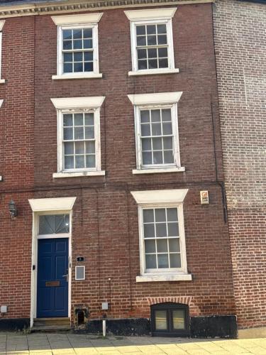 a brick building with a blue door and windows at St James's Terrace Studio Rooms in Nottingham