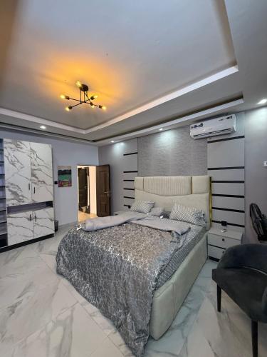 una camera con un grande letto e un soffitto di Quantum Havens Apartment - PARIS ad Akure
