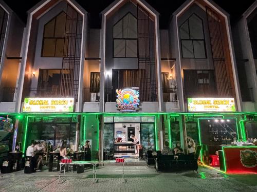 a restaurant with green lighting in front of a building at Global Beach Hostel - Ao Nang in Ban Khlong Haeng