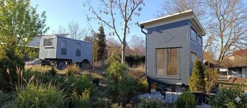 a tiny house and a truck in a yard at Boží maringotka in Humpolec