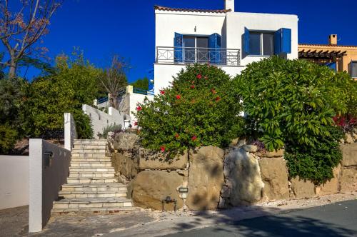 a white house with stairs and flowers in front at Kastalia Springs 3bd VIilla in Peiya by VICHY Holidays in Paphos