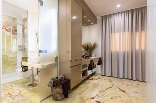 RovaniemiApartment with 3BDR - private Jacuzzi & Sauna的浴室里有淋浴、洗手池和镜子。