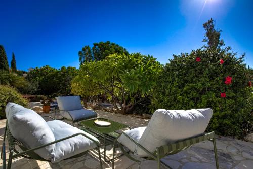 two chairs and a table on a patio at Kastalia Springs 3bd VIilla in Peiya by VICHY Holidays in Paphos