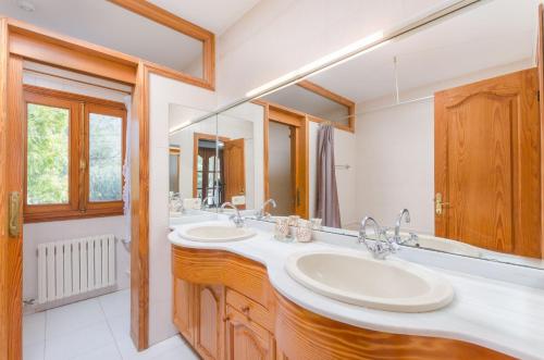 a bathroom with two sinks and a large mirror at YourHouse Can Marques villa in Palma de Mallorca