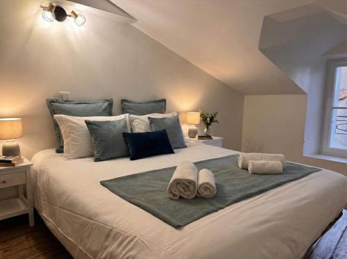 a bedroom with a large bed with towels on it at Logis du Mousquetaire -15min du Parc - by R&G in La Pommeraie-sur-Sèvre