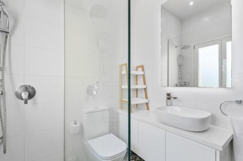 a white bathroom with a toilet and a sink at Beautiful Villa Pera with private pool and lovely gardens, Aphrodite Hills in Kouklia
