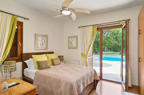 a bedroom with a bed and a ceiling fan at Beautiful Villa Pera with private pool and lovely gardens, Aphrodite Hills in Kouklia