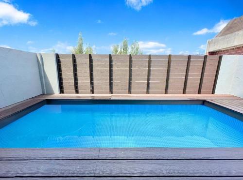 a swimming pool in front of a wooden fence at Grandioso Okinawa Pool Villa Onna - Vacation STAY 52628v in Inbu