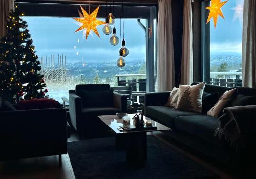ein Wohnzimmer mit einem Weihnachtsbaum und einer Couch in der Unterkunft Christmas-decorated mountain cabin - panoramic view! in Torvetjørn