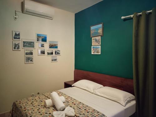 イニャンバネにあるHotel Bom Amigoの緑の壁のベッドのある寝室