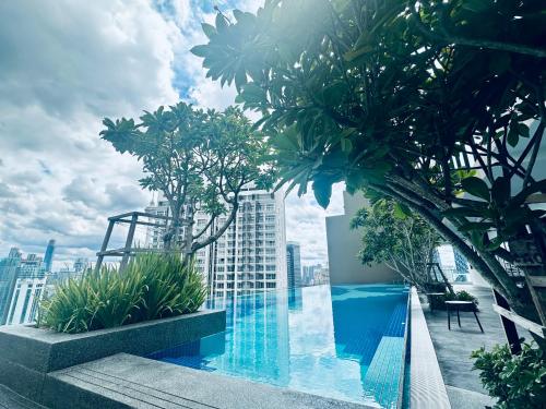 a swimming pool on top of a building with trees at Majestic Residence KLCC By Homestay in Kuala Lumpur