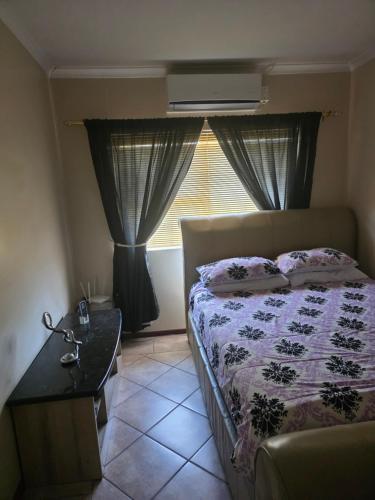 a bedroom with a bed and a window at Peters Place in Kuilsrivier