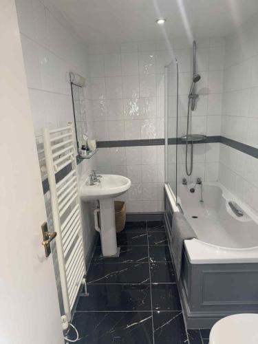 a bathroom with a sink and a tub and a toilet at The Eelsfoot inn in Theberton